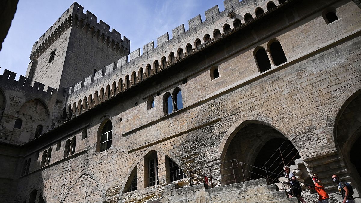 Des touristes visitent le Palais des Papes à Avignon en France le 10 août 2020