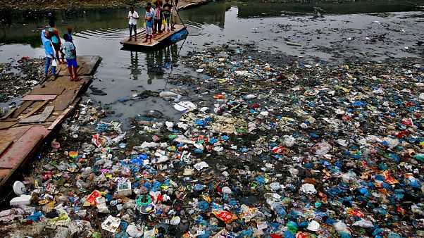 Oct. 2, 2016 file photo: a man guides a raft through a polluted canal littered with plastic bags and other garbage in Mumbai, India. Oct. 2, 2016 file photo: a man guides a raft through a polluted canal littered with plastic bags and other garbage in Mumbai, India.