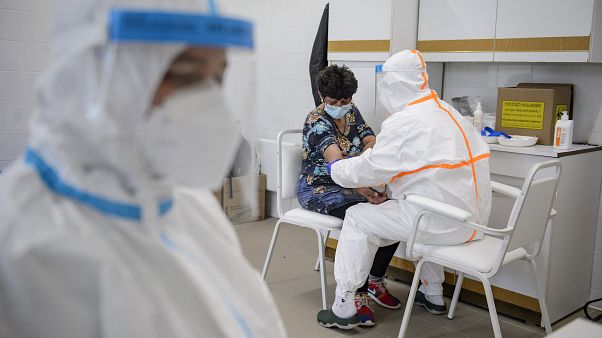 Vért vesz egy nőtől a koronavírus-teszthez a Semmelweis Egyetem szakembere a sziráki orvosi rendelőben 2020. május 8-án. Vért vesz egy nőtől a koronavírus-teszthez a Semmelweis Egyetem szakembere a sziráki orvosi rendelőben 2020. május 8-án.