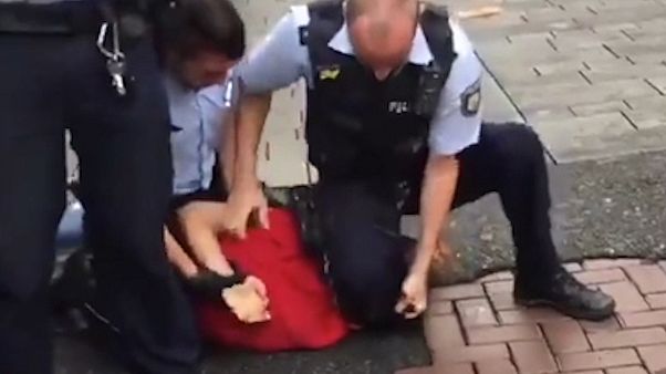 Düsseldorf'ta polislerin yere yatırdıkları gencin boğazına bastığı görüntülerin ardından soruşturma başlatıldı Düsseldorf'ta polislerin yere yatırdıkları gencin boğazına bastığı görüntülerin ardından soruşturma başlatıldı