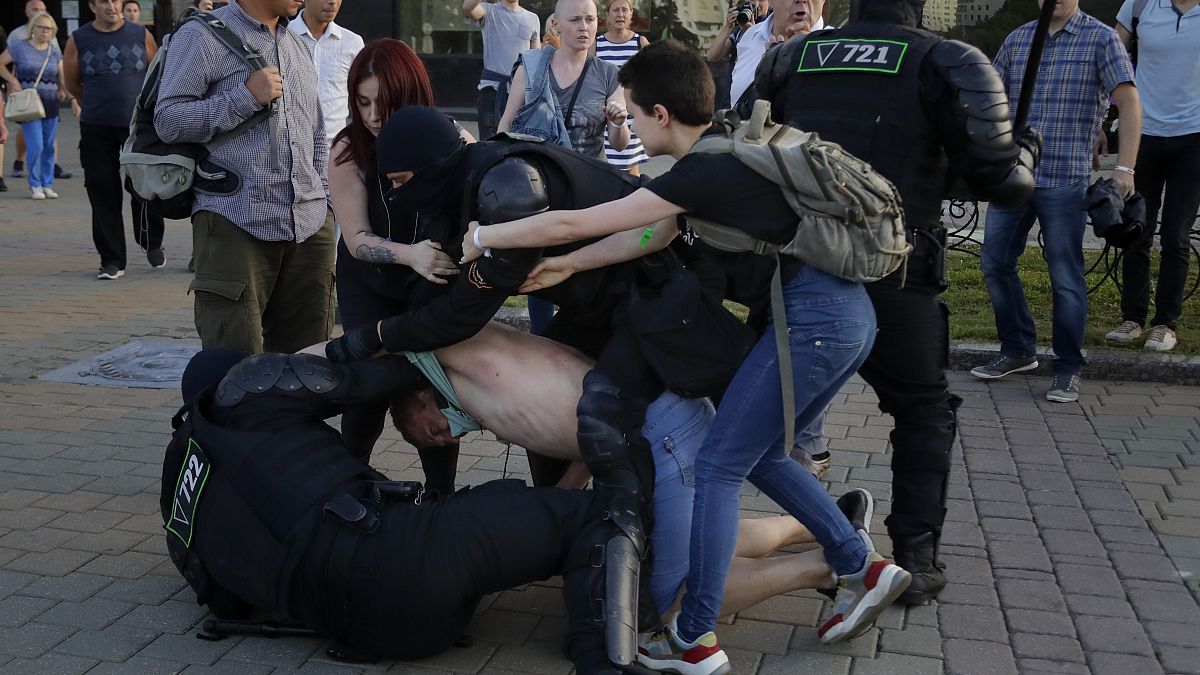 La policía detiene a un manifestante mientras dos mujeres tratan de defenderlo durante una manifestación contra las disputadas elecciones presidenciales en Minsk, Bielorrusia.