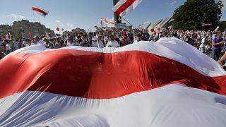 Opposition supporters wave an old Belarusian national flag at a rally in Minsk on Sunday.