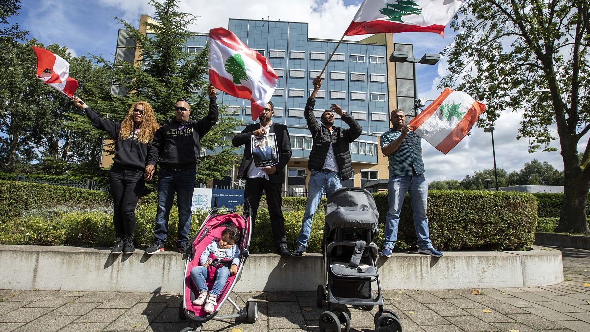 مواطنون  يحملون أعلام لبنان خلال جلسة المحاكمة في قضية رفيق الحريري في لاهاي