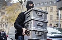 Police carry boxes after investigations at a jeweler in Duisburg-Marxloh, western Germany