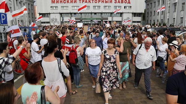 Workers leave the Minsk Tractor Works at the end of a shift on Tuesday, applauded by opposition workers Workers leave the Minsk Tractor Works at the end of a shift on Tuesday, applauded by opposition workers