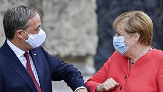 Канцлер Германии Ангела Меркель здоровается с премьер-министром федеральной земли Северный Рейн-Вестфалия. 