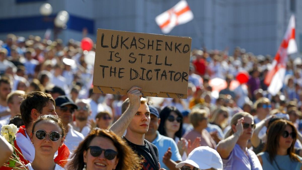 Belarus'un başkenti Minsk'te düzenlenen gösteride bir eylemci, "Lukaşenko hala diktatör" yazılı pankart taşıdı