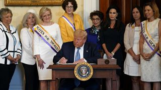 دونالد ترامپ در حال امضای اعلامیه‌ای در گرامیداشت صدمین سالگرد اعطای حق رای به زنان در آمریکا