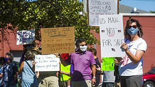 gather in front of the United States Post Office to protest recent changes to the USPS under new Postmaster General Louis DeJoy, Tuesday, Aug. 11, 2020 in Midland, Michigan