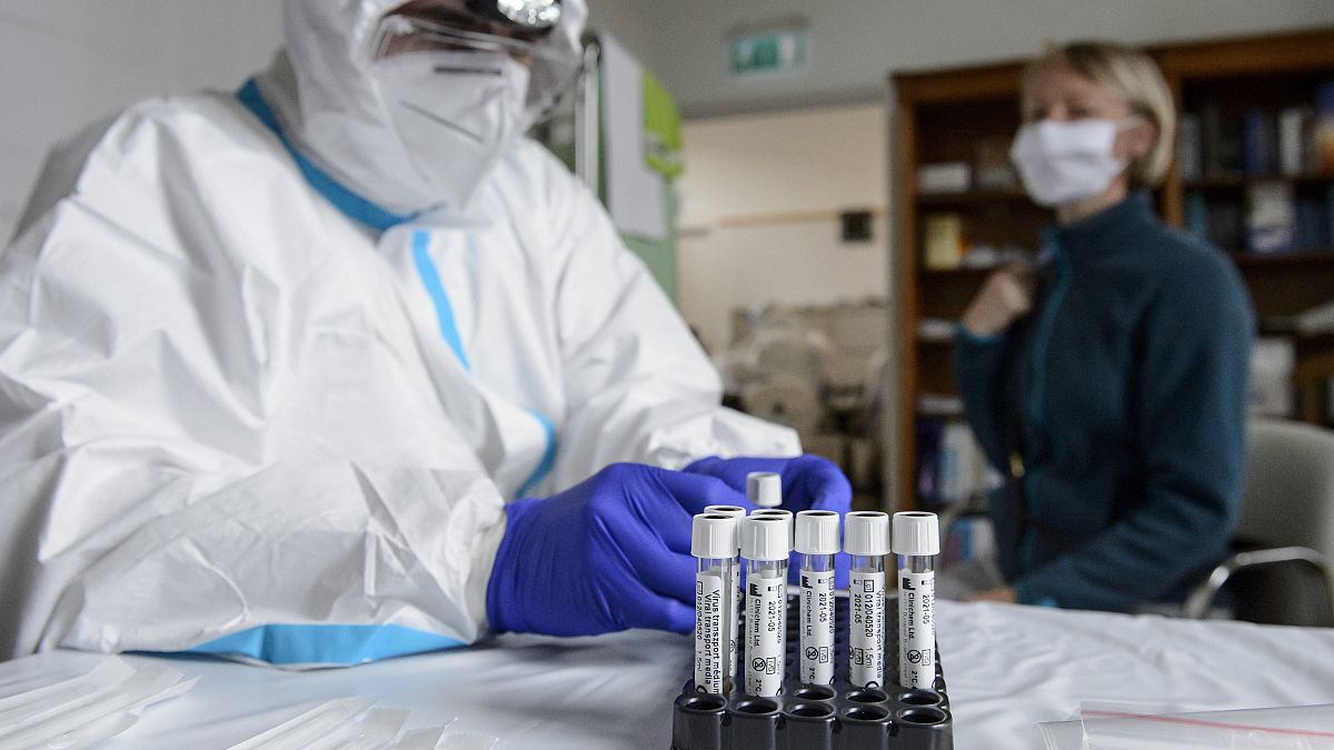 A Debreceni Egyetem szakembere egy nő garatnyálkahártyájáról készül mintát venni a koronavírus-teszthez az intézmény egyik mintavételi pontján