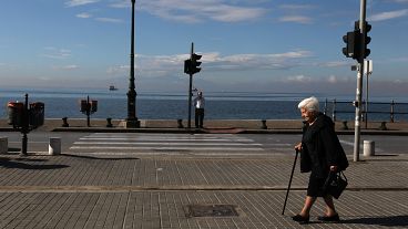 Elderly people walk along a coastal avenue in the northern Greek port city of Thessaloniki.
