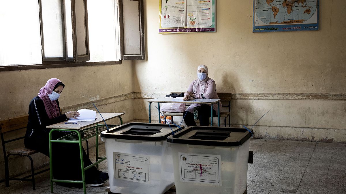Election officials wait for people to vote on the first day of the Senate elections inside a polling station in Cairo, Egypt, Tuesday, Aug. 11, 2020