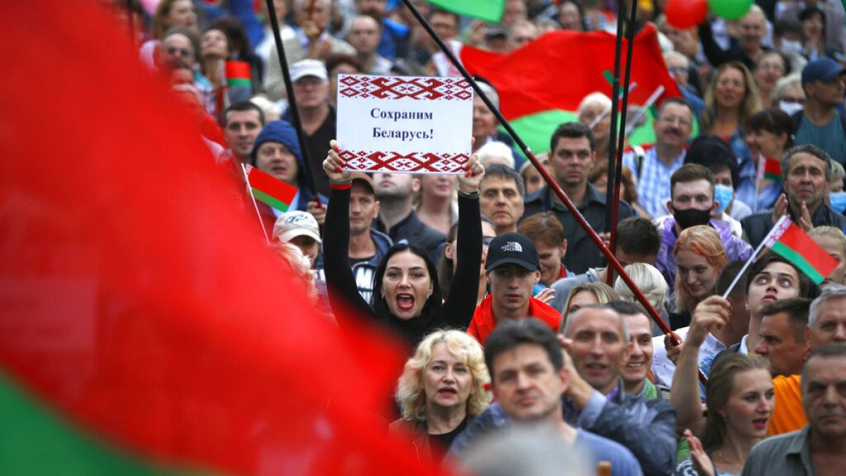 "Save Belarus!" reads the poster a woman is holding among demonstrators in Minsk