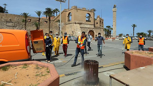 عمال ليبيون يقومون بتطهير شارع في وسط العاصمة طرابلس، 1 أبريل 2020 عمال ليبيون يقومون بتطهير شارع في وسط العاصمة طرابلس، 1 أبريل 2020