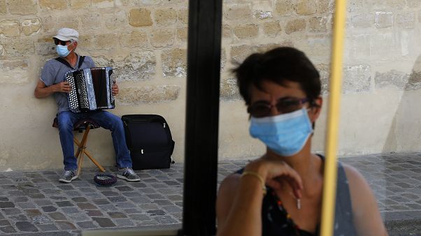 An accordionist wearing a face mask performs in the Montmartre district Monday, Aug. 10, 2020 in Paris. An accordionist wearing a face mask performs in the Montmartre district Monday, Aug. 10, 2020 in Paris.