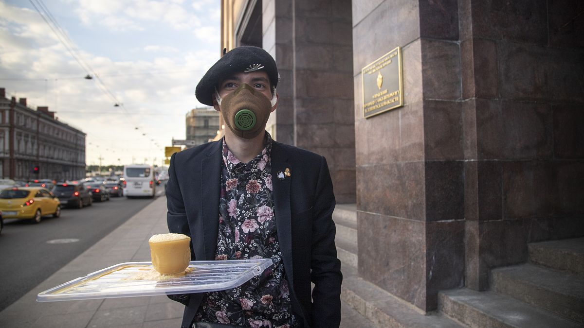 A protester holds a symbolic cup of tea as he comes to support Russian opposition leader Alexei Navalny in front of the building of the FSB,