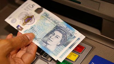 a member of staff at a branch of Halifax bank, in London, displays a new British 5 pound sterling note, made from polymer, which is being launched Tuesday, Sept, 13, 2016