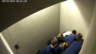 Police officers subdue Slovak man, Jozef Chovanec in this image taken from CCTV inside a cell at Charleroi airport in Belgium on Feb. 24, 2018. 