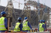 Workers walk to the Lusail Stadium, one of the 2022 World Cup stadiums, in Lusail, Qatar, Friday, Dec. 20, 2019.