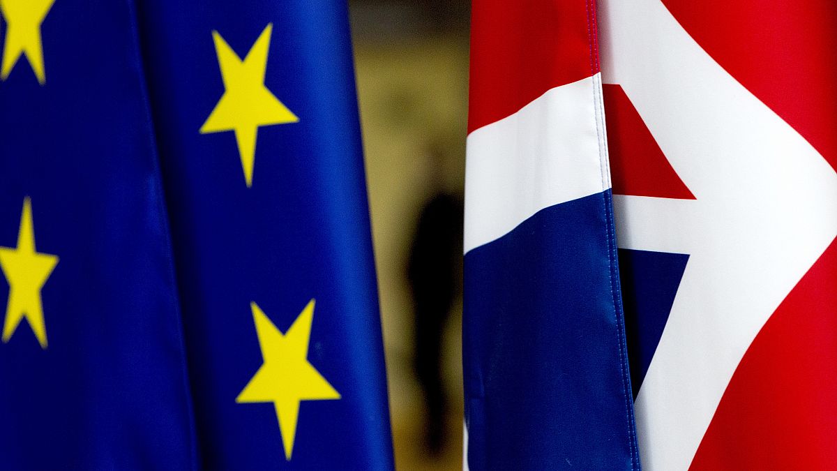 In this file photo dated Tuesday, January 28, 2020, the EU and UK flags are seen inside the atrium at the Europa building in Brussels. 