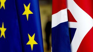 In this file photo dated Tuesday, January 28, 2020, the EU and UK flags are seen inside the atrium at the Europa building in Brussels. 