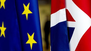 In this file photo dated Tuesday, January 28, 2020, the EU and UK flags are seen inside the atrium at the Europa building in Brussels. 