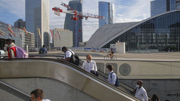 Usarios del metro salen de la estación con las mascarillas puestas en el barrio parisino de "La Defense" Usarios del metro salen de la estación con las mascarillas puestas en el barrio parisino de "La Defense"
