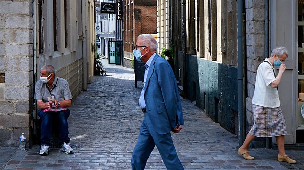 People wearing a protective face masks as a precaution against the coronavirus are seen in a street of Lille, northern France, Friday, Aug. 21, 2020