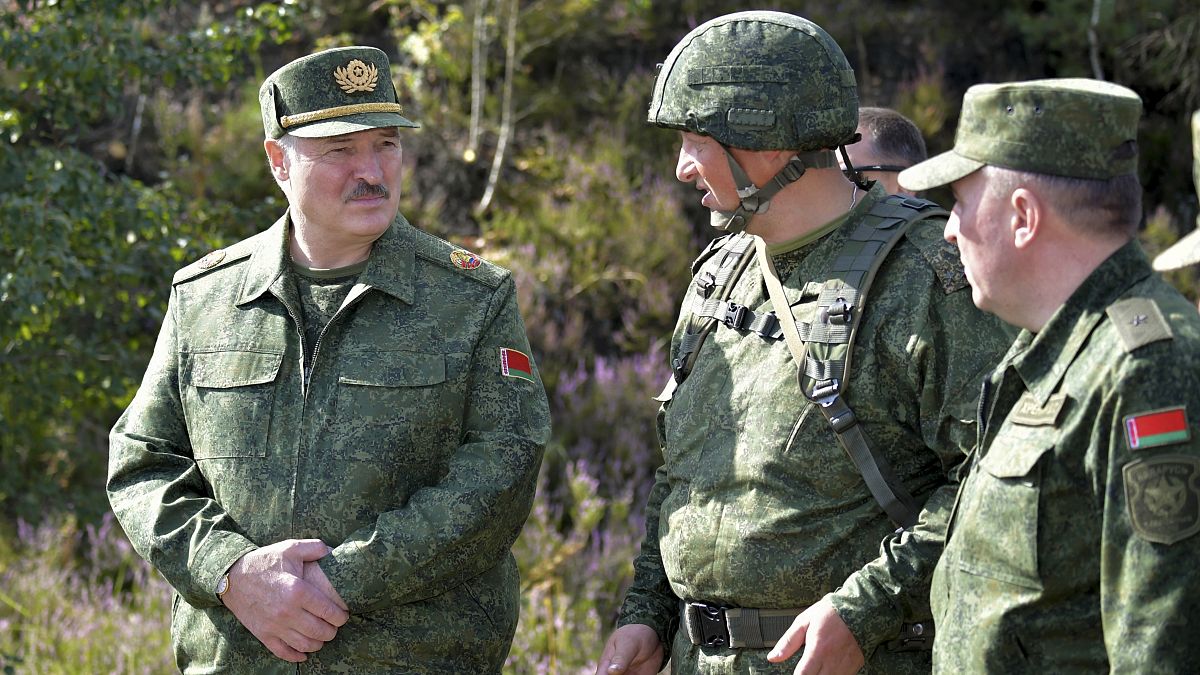 Belarusian President Alexander Lukashenko, left, speaks to high rank officers as he visits a military exercise near Grodno, Belarus.