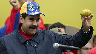 Venezuela's President Nicolas Maduro shows a mango