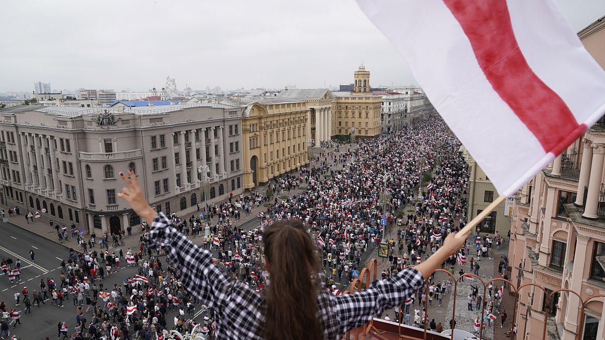 Una mujer ondea una bandera durante la marcha de la oposición en Minsk, Bielorrusia