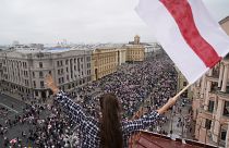 Una mujer ondea una bandera durante la marcha de la oposición en Minsk, Bielorrusia