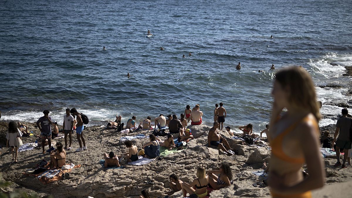 Gente disfruta del sol en la playa de Malmousque de Marsella