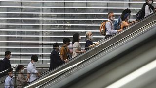 People wearing face masks to help protect against the spread of the coronavirus ride an escalator as they arrive at the Seoul Railway Station in Seoul