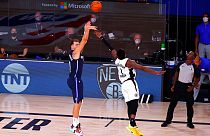 Dallas Mavericks' Luka Doncic, left, hits a winning three-point basket against Los Angeles Clippers' Reggie Jackson.