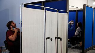 Medical staff conduct a test for the new coronavirus on passengers at Athens Aiport (File Photo)