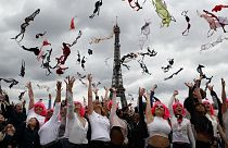 Tens of women throw their bras into the air as part of the annual Pink Bra Toss, in front of the Eiffel Tower, in Paris