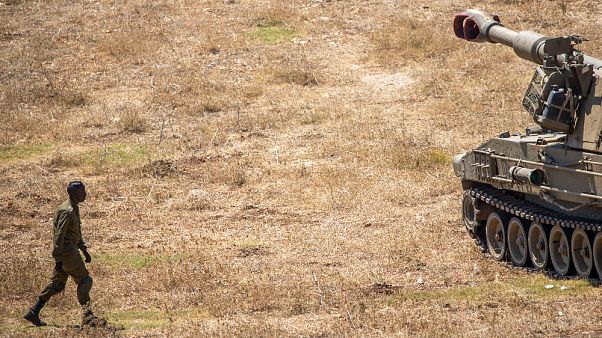 Un soldato israeliano cammina verso un carro armato vicino al confine con il Libano Un soldato israeliano cammina verso un carro armato vicino al confine con il Libano