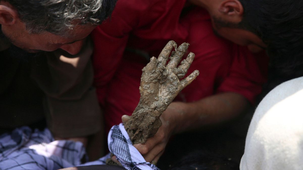 La mano ricoperta di fango di un bambino salvato, dopo le alluvioni nella provincia di Parvan, Afghanistan