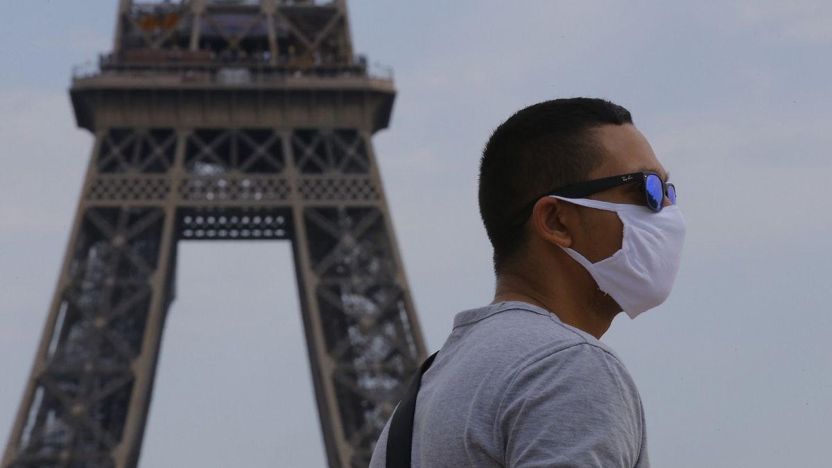 A man wearing a mask to prevent the spread of COVID-19 walks at Trocadero plaza near Eiffel Tower in Paris