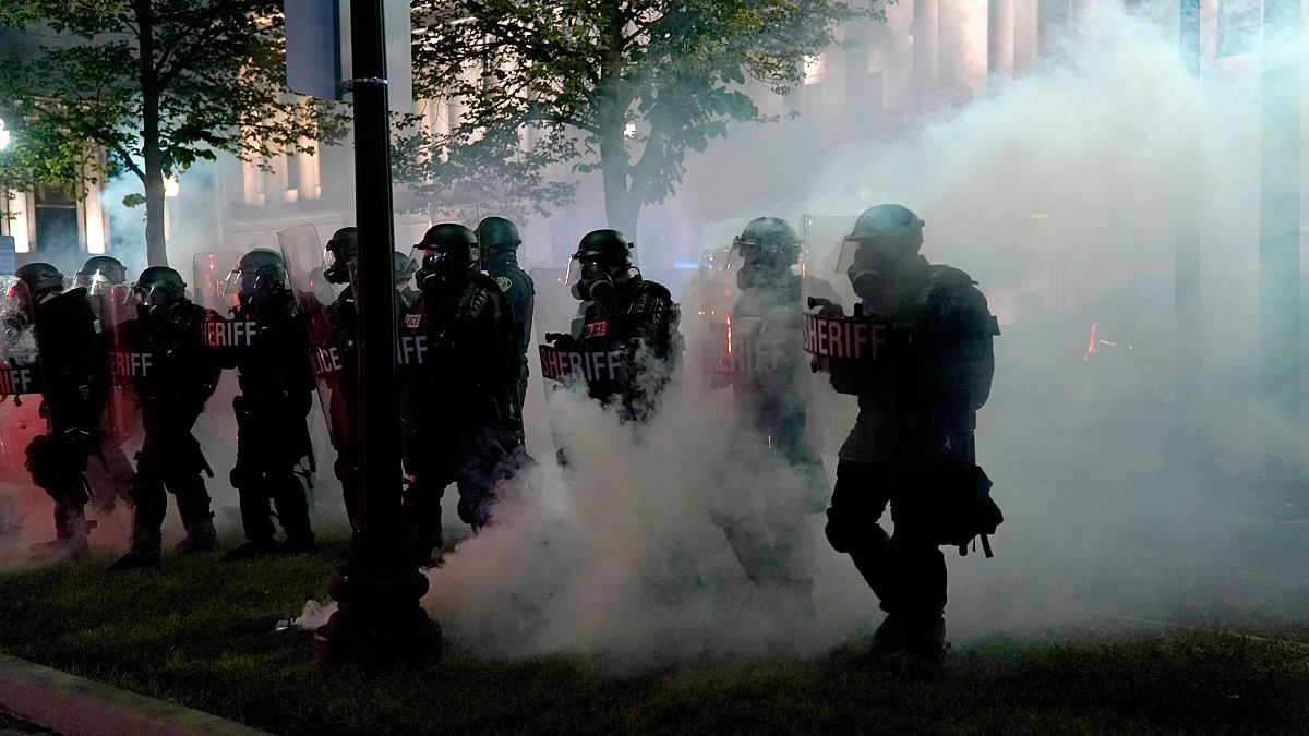 Police clear a park during clashes with protesters outside the Kenosha County Courthouse late Tuesday, Aug. 25