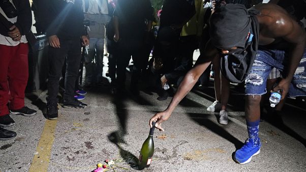 Un manifestant place une bouteille à l'endroit où un homme a été tué par balle mardi soir, lors de manifestations, à Kenosha, États-Unis, le 26 août 2020 Un manifestant place une bouteille à l'endroit où un homme a été tué par balle mardi soir, lors de manifestations, à Kenosha, États-Unis, le 26 août 2020