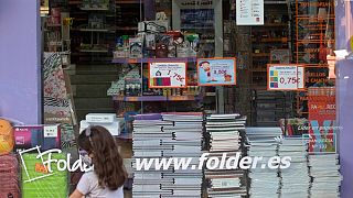 Una bambina - con mascherina - davanti a una cartoleria a Madrid, Spagna