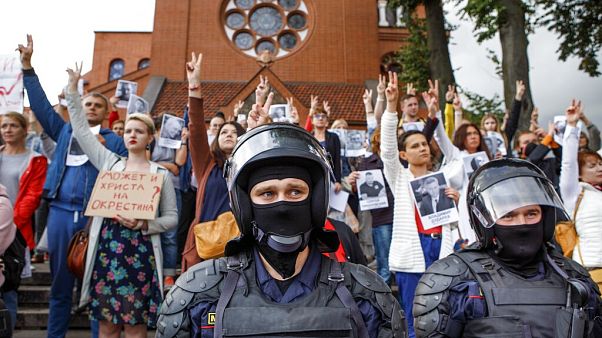 Riot police block protesters in front of a Catholic church in Minsk, Belarus. Riot police block protesters in front of a Catholic church in Minsk, Belarus.