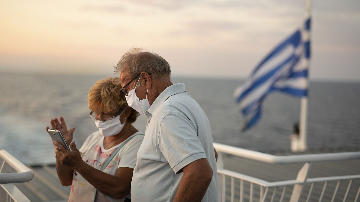 Ένα ζευγάρι φοράει μάσκες και ταξιδεύει με πλοίο