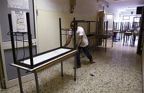 A worker pushes away the old double desks to be substituted by the new single ones for the start of the new school year, at the Isacco Newton high school institute in Rome Wed