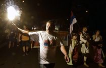 An opposition supporter lights torch during church-led protest in Podgorica, Montenegro, Thursday, Aug. 27, 2020.