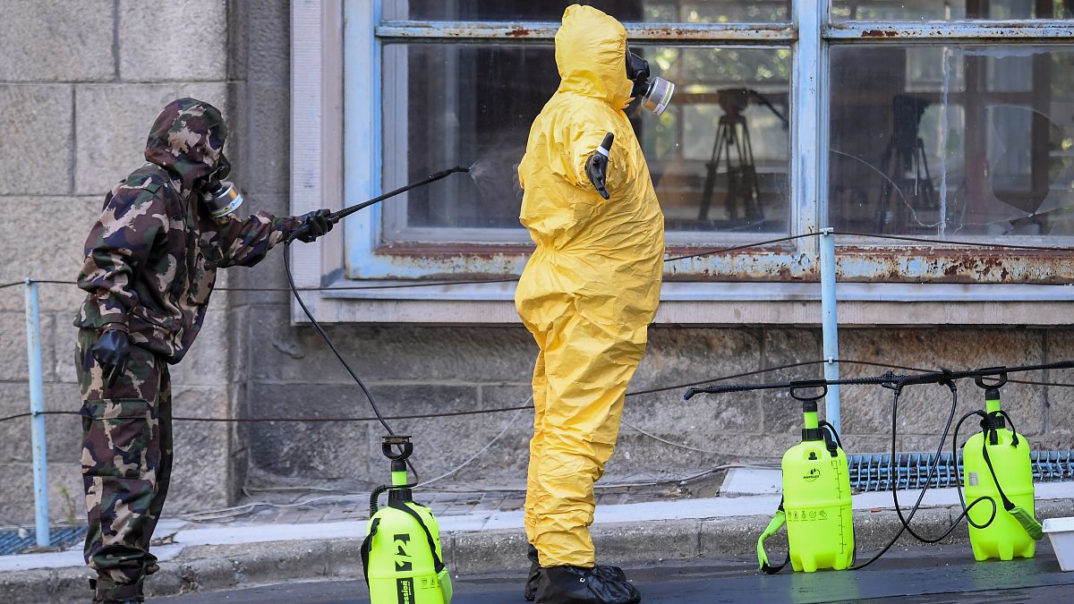 Participants of an exercise wear protective suits as they disinfect themselves in front of the Kutvolgyi hospital in Budapest.