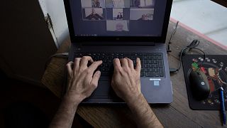 A man takes part in a video conference as he works from home, on May 14, 2020 in Vertou, outside Nantes