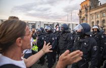 Police officers push away a crowd of demonstrators from the square 'Platz der Republik' in front of the Reichstag building. 